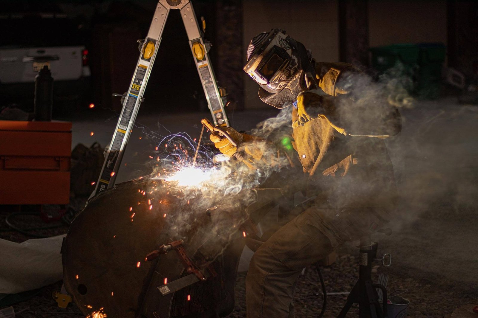 A welder gives a thumbs up to the camera while while running a bead on a project.