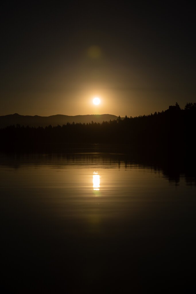 A picture of the Sun as it rises above the mountain tops across the waters of Lake Tahoe.